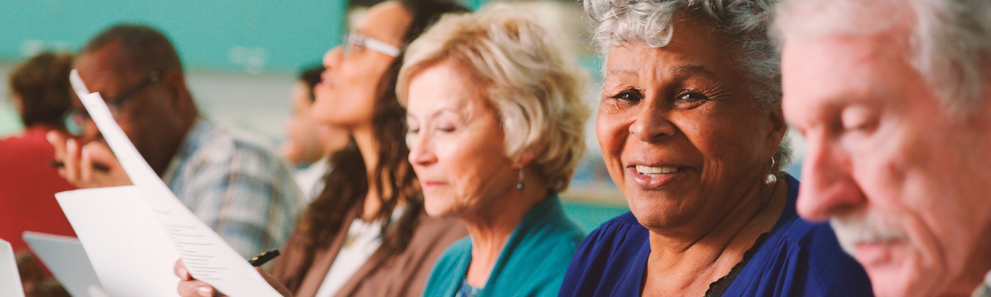 Groups of students sharing and discussing their essays in an adult and continuing education class