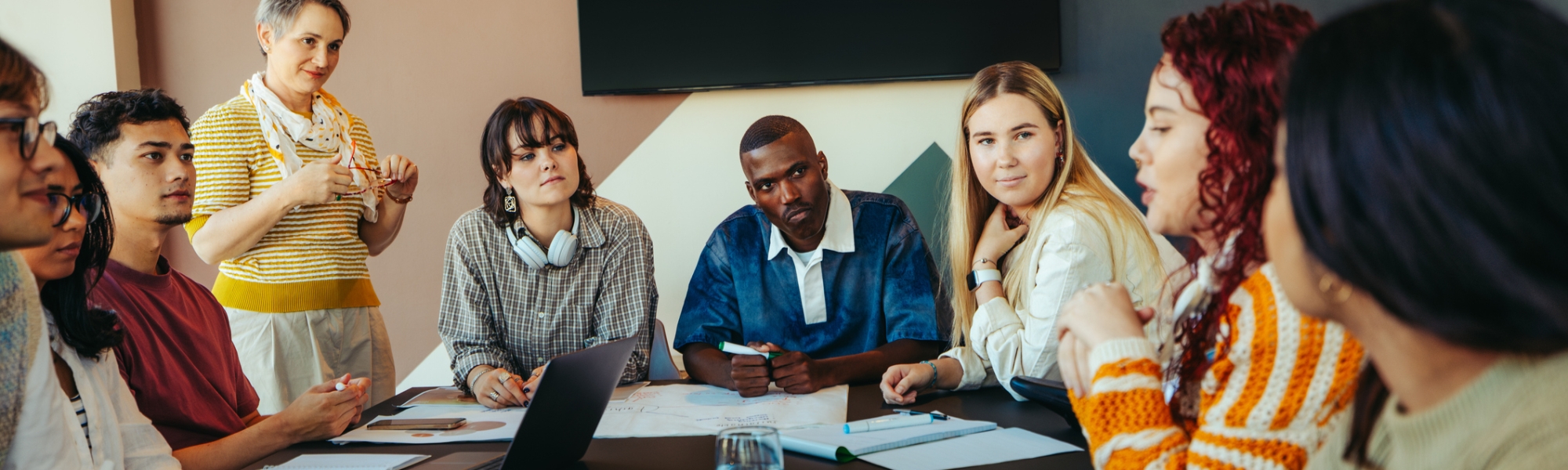 An instructor with a diverse group of university students in discussion around a conference table